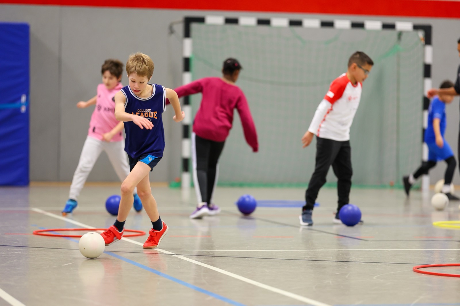 Ein Kind am Ball in der Sporthalle